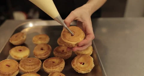 The confectioner fills the eclair with cream using a pastry syringe. Stock Footage 254817622