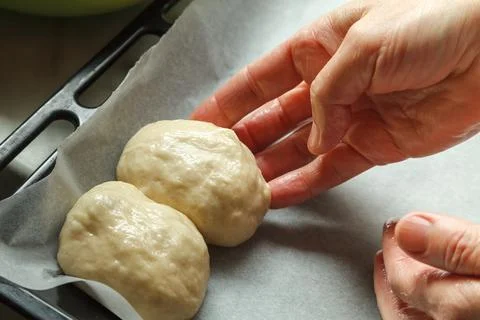 Confectioner forms buns with cherries from baking dough 写真素材