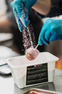 Confectioner in gloves makes chocolates in forms Stock Photos