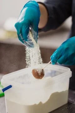 Confectioner in gloves makes chocolates in forms Stock Photos