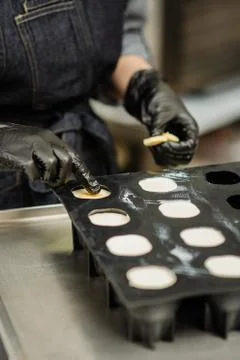 Confectioner in gloves makes chocolates in forms Stock Photos