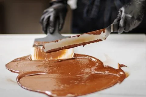 Confectioner in gloves makes chocolates in forms Stock Photos