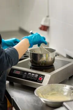 Confectioner in gloves makes chocolates in forms Stock Photos