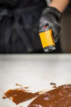 Confectioner in gloves makes chocolates in forms Stock Photos