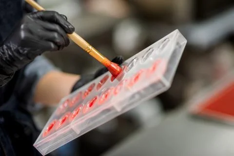 Confectioner in gloves makes chocolates in forms Stock Photos