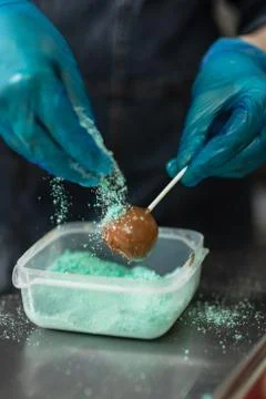 Confectioner in gloves makes chocolates in forms Stock Photos