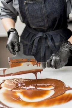 Confectioner in gloves makes chocolates in forms Stock Photos