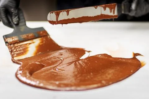 Confectioner in gloves makes chocolates in forms Stock Photos