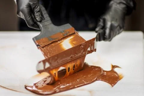Confectioner in gloves makes chocolates in forms Stock Photos