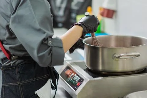 Confectioner in gloves makes chocolates in forms Stock Photos