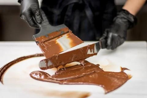 Confectioner in gloves makes chocolates in forms Stock Photos