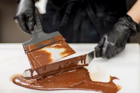 Confectioner in gloves makes chocolates in forms Stock Photos