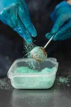 Confectioner in gloves makes chocolates in forms Stock Photos