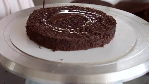 Confectioner impregnating chocolate sponge layer of cake with chocolate syrup Stock Footage 163158058