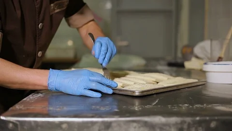 The confectioner makes punctures with a fork on the dough Stock-Footage 106478366