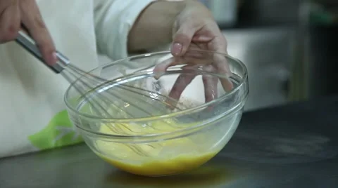 Confectioner mixing eggs using fouet Stock-Footage 64485502