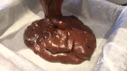 Confectioner pouring dough into a mold, to make a brownie Stock Footage 142446446