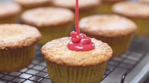 Confectioner pours raspberry icing on the muffin. Stock Footage 150829662