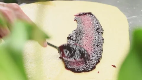 The confectioner preparing raspberry babka. Spreading raspberry jam on a dough. Stock Footage 166342642