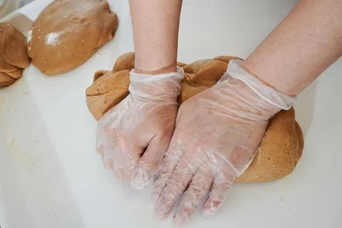 Confectioner in the process of preparing dough, hands in protective gloves in Stock Photos