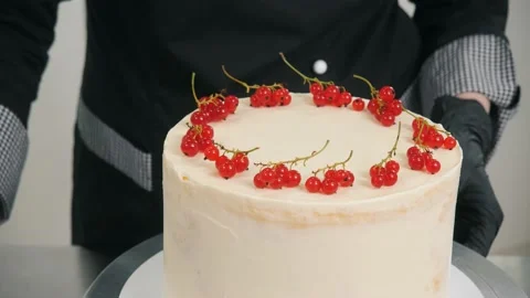 Confectioner puts red currant berries decorating tasty cake Stock Footage 139487013