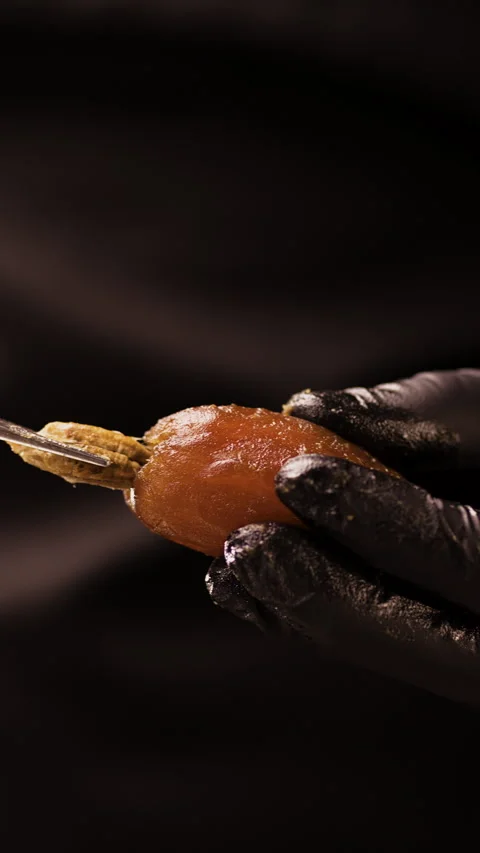 Confectioner removes the pit from a ripe date to prepare the fruit for vegan 스톡 동영상 306170097