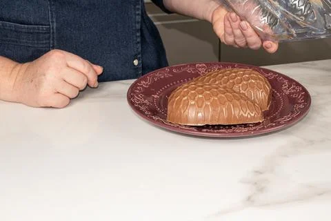 Confectioner removing chocolate Easter egg mold. Stock Photos