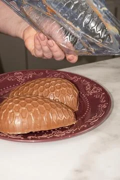 Confectioner removing chocolate Easter egg mold vertical. Stock Photos