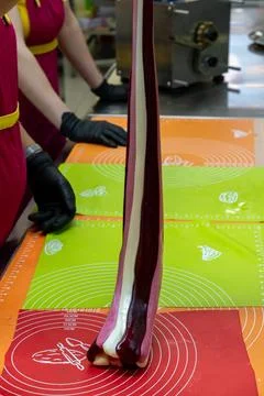 Confectioner Rolling Thick Multicolored Caramel Loaf on Silicone Table Mat Fotos Stock