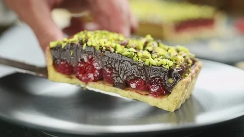 The confectioner serves a piece of chocolate raspberry tart. Stock Footage 202072104