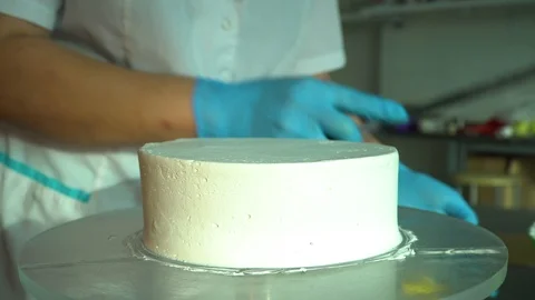 Confectioner smears a cream on the form of a cake Stock Footage 85664650