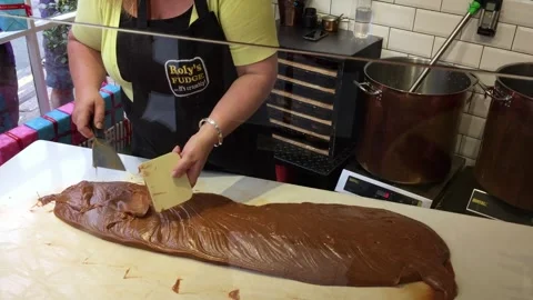 Confectioner spreading and shaping fresh fudge on marble slab during Stock Footage 335206672