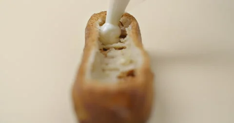 Confectioner is stuffing the eclair with fruit jam and cream Stock Footage 143781699