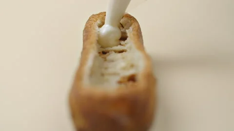 Confectioner is stuffing the eclair with fruit jam and cream Stock Footage 143781990