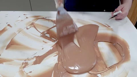 A confectioner tempering chocolate on a marble countertop. Stock Footage 328052060