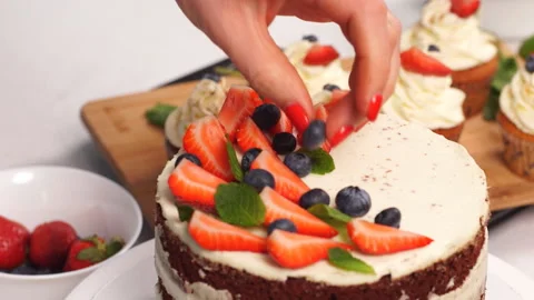 Confectioner woman is decorating delicious cake in studio Stock Footage 108333053