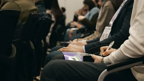 Conference audience taking notes during business seminar event. 스톡 동영상 347784925