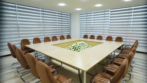 Conference room. Big rectangle table. White flowers in center. Brown armchai Stock Footage 162117083