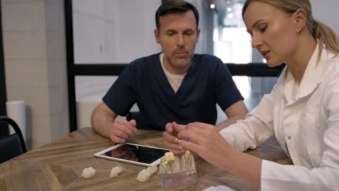 Conference of two doctors over tooth implants in the meeting room Stock Footage 274141096