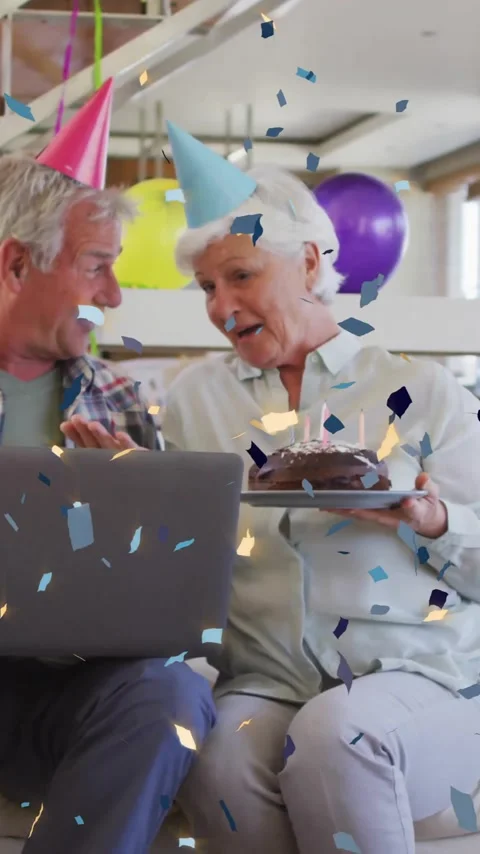 Confetti animation over elderly couple celebrating birthday with cake and laptop Vídeo Stock 343902732