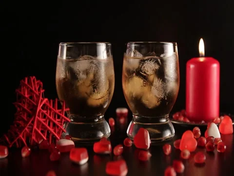 Confetti falling down slow motion. Two glasses with alcohol decorated. Stock Footage 71580544