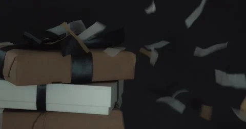Confetti Falls On Gift Stack with a Black Background Stock Footage 130873710