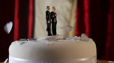 Confetti falls in slow mo on same sex wedding cake Stock Footage 50008445