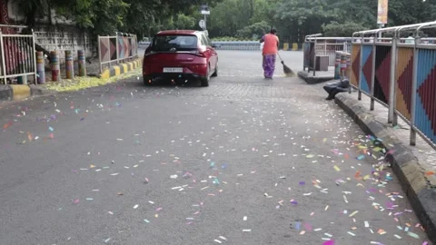 Confetti filled streets being cleaned by a sanitation staff Stock Footage 284830824