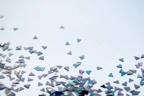 Confetti triangles on white background, luminous plastic pieces reflecting light Stock Photos