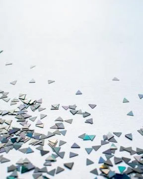 Confetti triangles on white background, stylish luminous plastic pieces Stock Photos