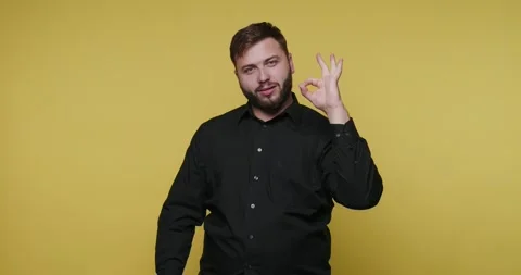 Confidence shines in a bright setting as a man displays a gesture of approv.. Видео 329110974