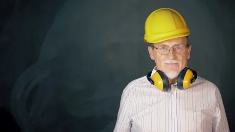 Confidence worker with thumb up wearing a safety helmet over a grey background Stock Footage 133257596