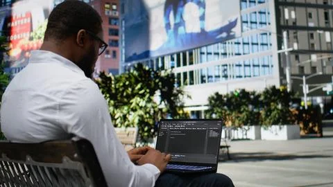 Confident adult reviews binary code script for his programming remote work Stock-Fotos