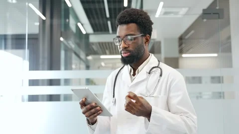 Confident african american doctor using digital tablet for virtual medical Stock Footage 293706775